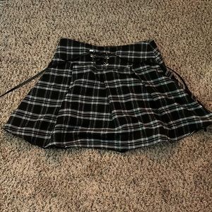black, flannel-patterned flowy miniskirt with ties on the back